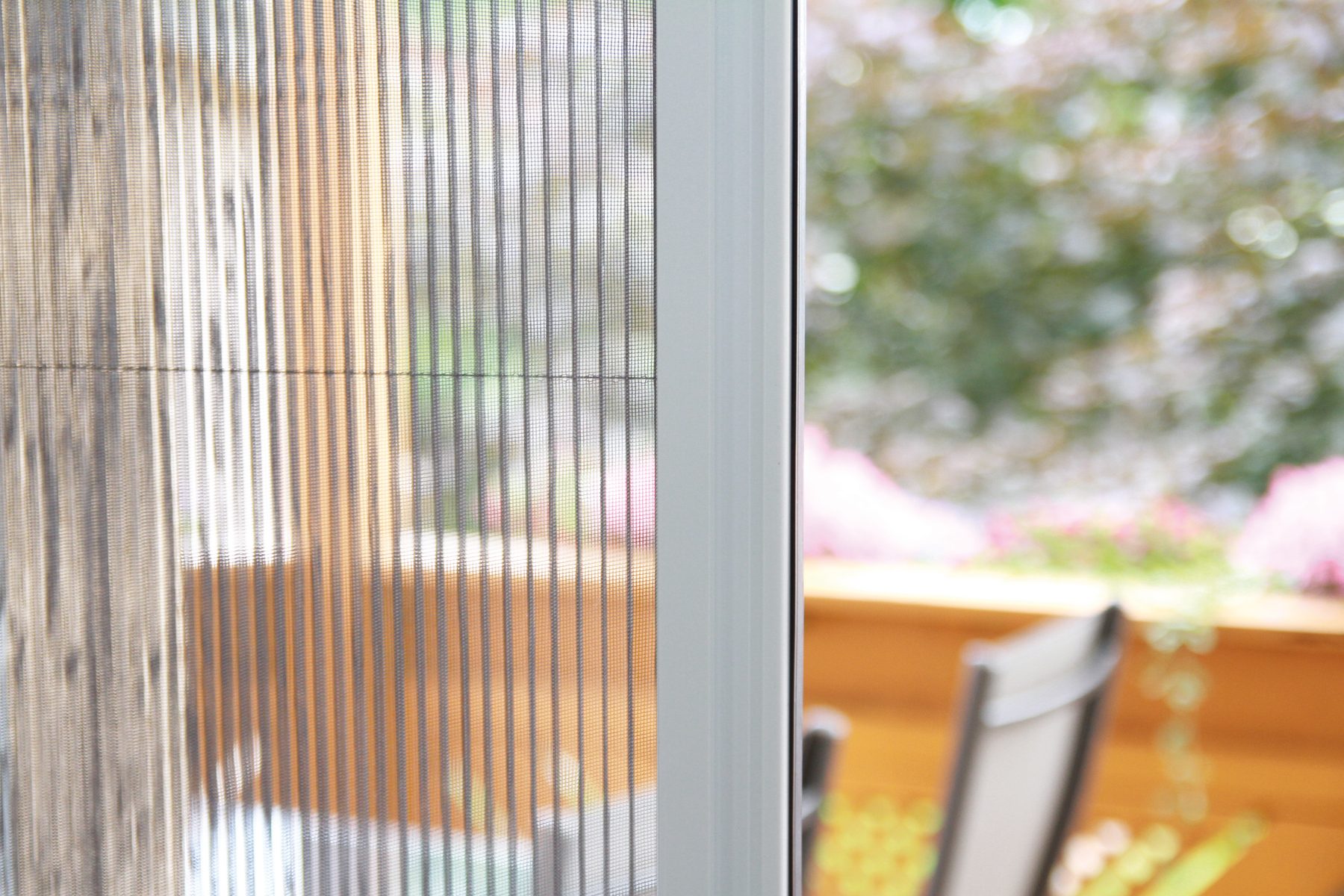 Detailaufnahme eines Insektenschutzgitters am Fensterrahmen